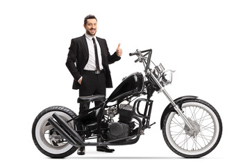 Fototapeta na wymiar Man in a black suit standing with a chopper motorbike and showing thumbs up