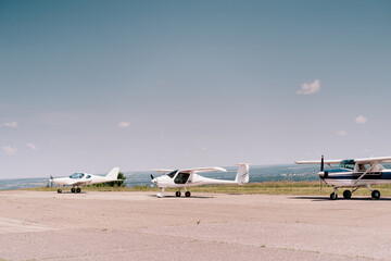 Small propeller sport airplane in the field waiting to take off with sky in background. Private...