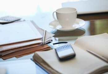 Notebook, cell phone and cup of coffee on desk