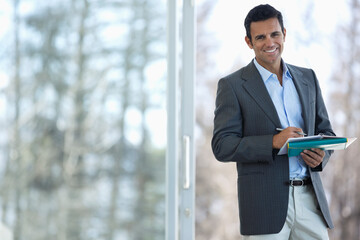 Fototapeta premium Businessman making notes at office window