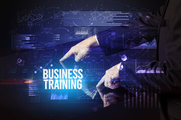 Businessman touching huge screen with BUSINESS TRAINING inscription, cyber business concept