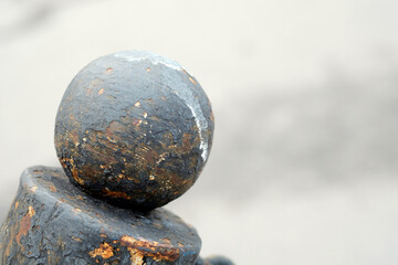Fototapeta na wymiar rusty metal ball with peeling paint on a gray blurred background.