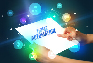 Holding futuristic tablet with HOME AUTOMATION inscription, new technology concept