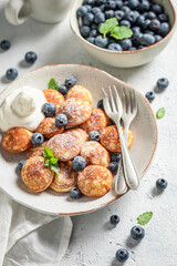 Delicious mini pancakes with fresh berries and powdered sugar
