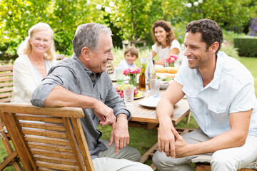 Family sitting at table outdoors