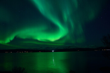 insanly strong aurora borealis over arctic fjord and mountain landscape