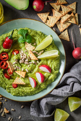 Fresh guacamole served with crackers, coriander and sunflower seeds
