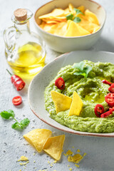 Homemade guacamole with tortilla, coriander and chilli peppers