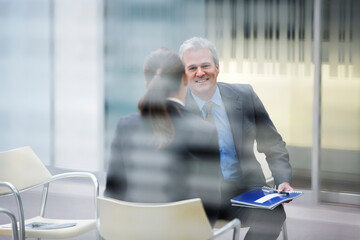 Fototapeta premium Smiling businessman talking to businesswoman
