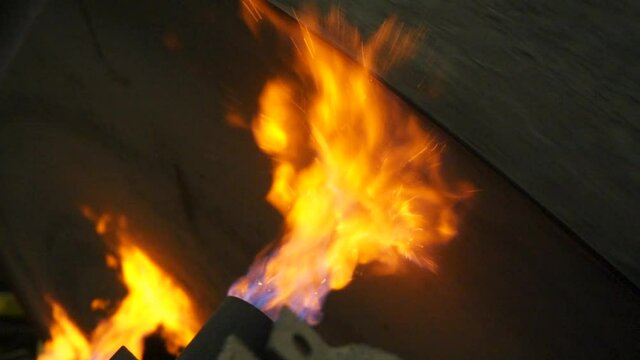 Close up of firing process in the hot shop of the factory. Stock footage. Industrial background with rotating shaft being fired at the iron casting plant.