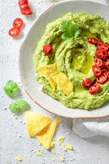 Vegan guacamole with nachos, chilli peppers and coriander