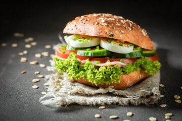 Sandwich with tomato, lettuce, egg paste on dark table