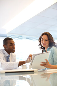 Businessman And Businesswoman Reviewing Paperwork