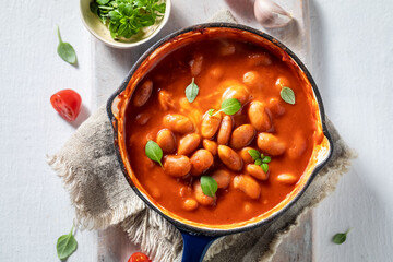 Top view of baked beans made of tomatoes and herbs