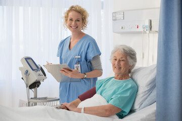Obraz premium Portrait of smiling nurse and senior patient in hospital room