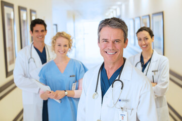 Fototapeta premium Portrait of smiling doctors and nurse in hospital corridor