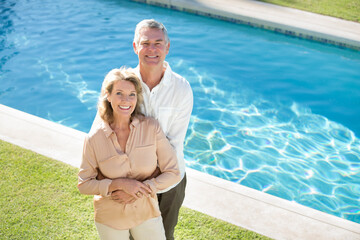 Portrait of smiling senior couple at poolside