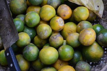 a pile of oranges in a basket sold in the market