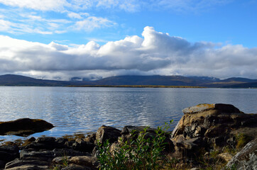 blue fjord, sunhine and thick clouds