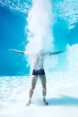 Man standing underwater in swimming pool