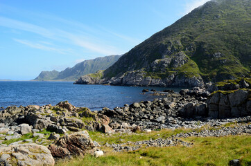 majestic blue ocean, mighty mountain and green field in summer