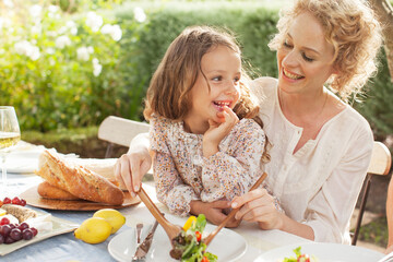 Mother and daughter eating in garden