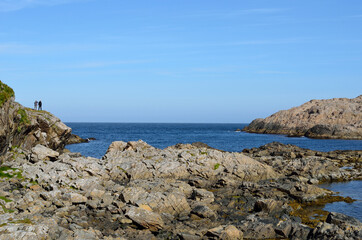 couple standing on cliff over blue ocean landscape in summer
