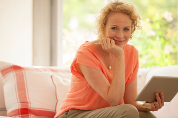 Portrait of woman using digital tablet on sofa