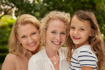 Three generations of women smiling outdoors