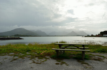 Obraz premium bench near sea shore with mountain background