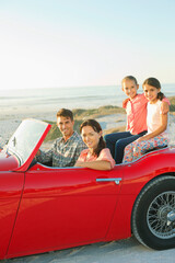 Family in convertible on beach