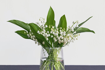 lily of the valley flower bouquet in glass vase with white background 