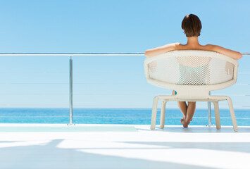 Woman in chair looking at ocean view