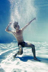 Man posing underwater in swimming pool