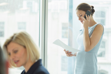 Fototapeta premium Businesswoman talking on cell phone in office