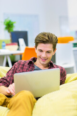 Businessman using laptop in bean bag chair in office