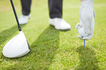 Man teeing golf ball on course