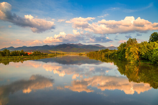 Mirroring of the mountainous landscape on the water surface of the dam at sunset. Zilina dam in the north of Slovakia, Europe.