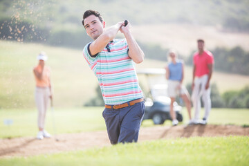 Friends playing golf on course