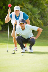 Caddy and golfer on putting green