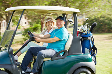 Senior couple driving golf cart on course © Chris Ryan/KOTO