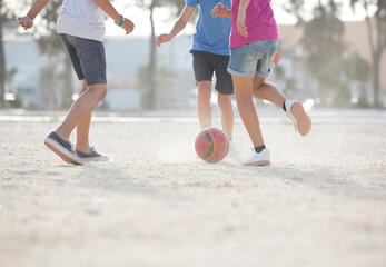 Children playing with soccer ball in sand