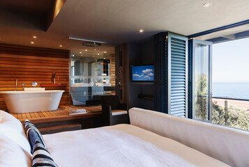 Modern master bedroom and bathroom overlooking ocean