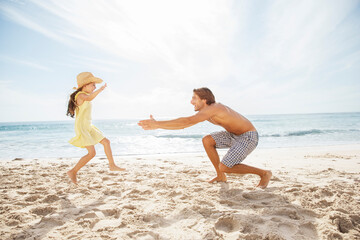 Father and daughter playing on beach