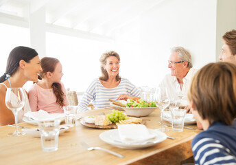 Multi-generation family eating together at table