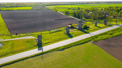Naklejka na ściany i meble Beautiful panoramic aerial view photo from flying drone to summer fields and Angla windmills in Leisi Parish. Saarema Island, Estonia. (series)