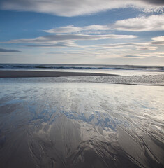 Clouds over beach at low tide