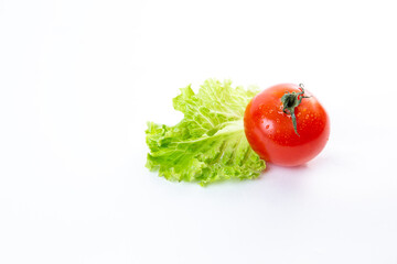 Juicy fresh red tomato and green lettuce salad isolated on white background.