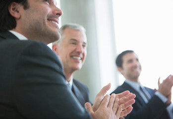 Businessmen clapping in meeting