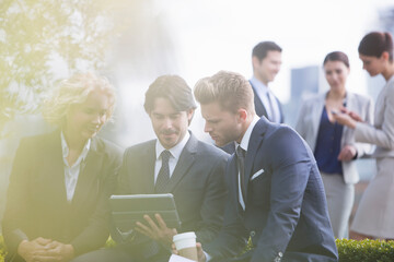 Business people using digital tablet outdoors